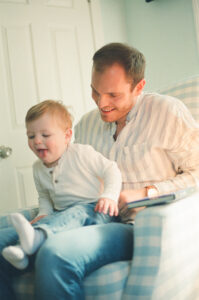 A father and son play in a blue and white nursery in Acton, Massachusetts.